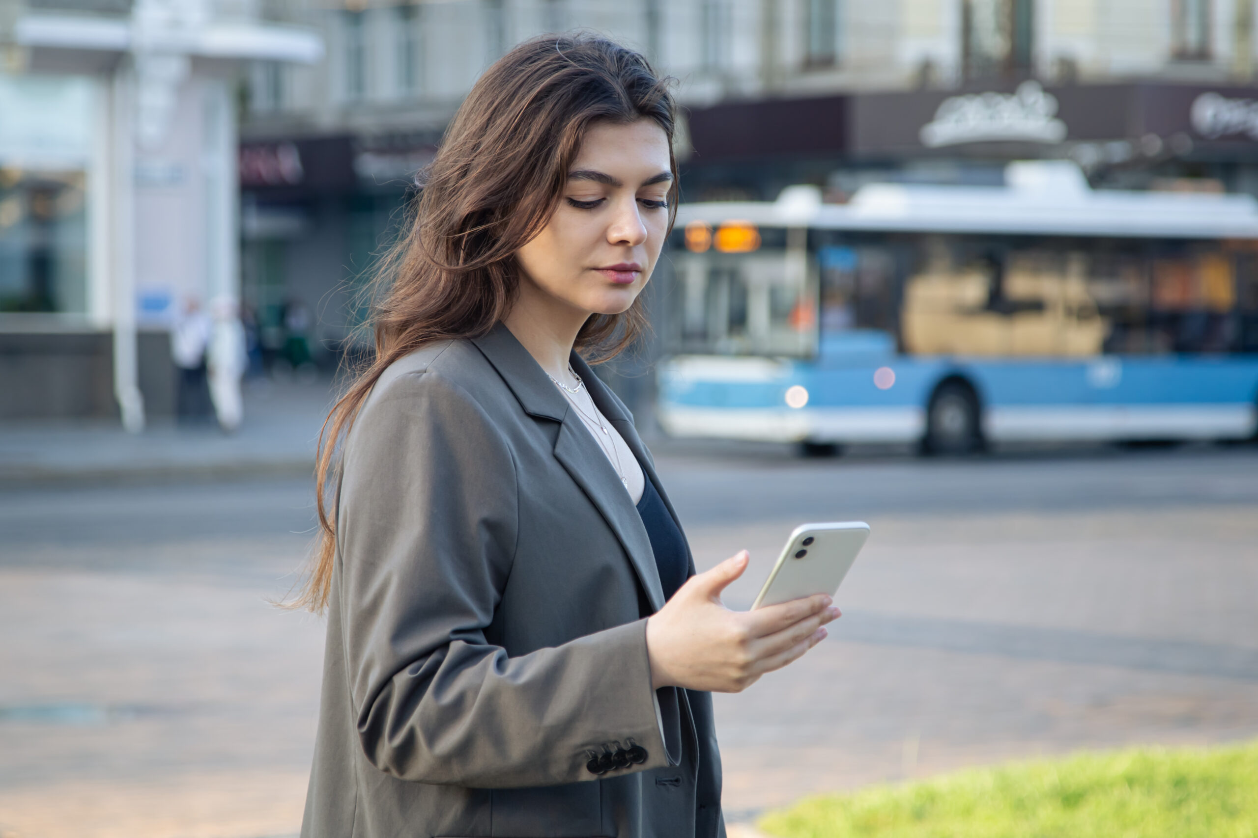 business young woman with smartphone blurred background city scaled